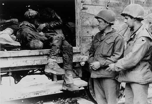 US Soldiers view bodies on a train car at Dachau